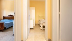 A narrow hallway with a bed on the left, a wardrobe, and a metal bed frame on the right. - 3294 Villa Dolce Grazia by Barbarhouse (Manduria)