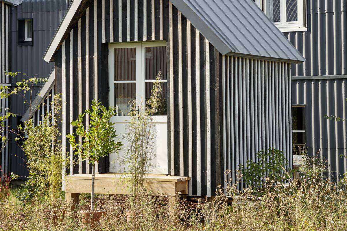 A modern house with a sloped roof and a wooden deck.
