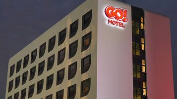 Ein Hotelgebäude mit einem gut sichtbaren Schild mit der Aufschrift „GO! HOTEL“ und zahlreichen Fenstern.