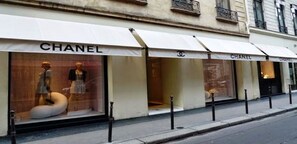 En Chanel butik med store vinduer, der viser mannequiner og en mannequin i en kjole.
