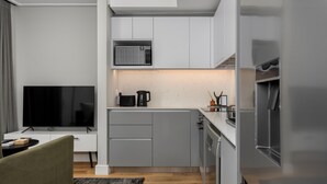 A modern kitchen with grey cabinets, a microwave, a coffee maker, and a refrigerator. - 7 on Bantry 301 (Cape Town)