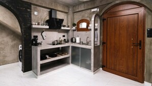 Una cocina moderna con horno integrado, un lavamanos y una puerta de madera.