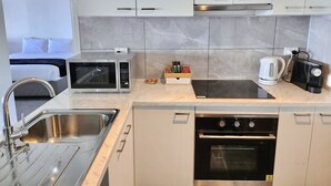 A modern kitchen with a built-in microwave, kettle, and oven. - Arthurs Holiday Villa (Arthurs Seat)
