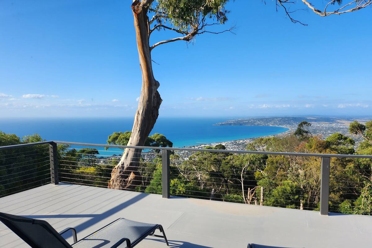 Un balcon avec deux fauteuils confortables donnant sur une vue panoramique de la côte.
