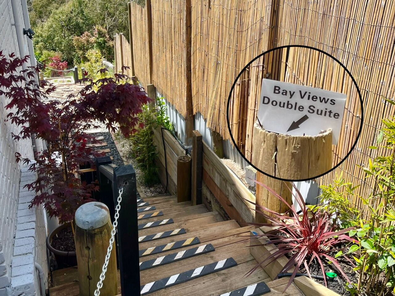 A wooden staircase leading to a room labeled "Bay Views Double Suite."