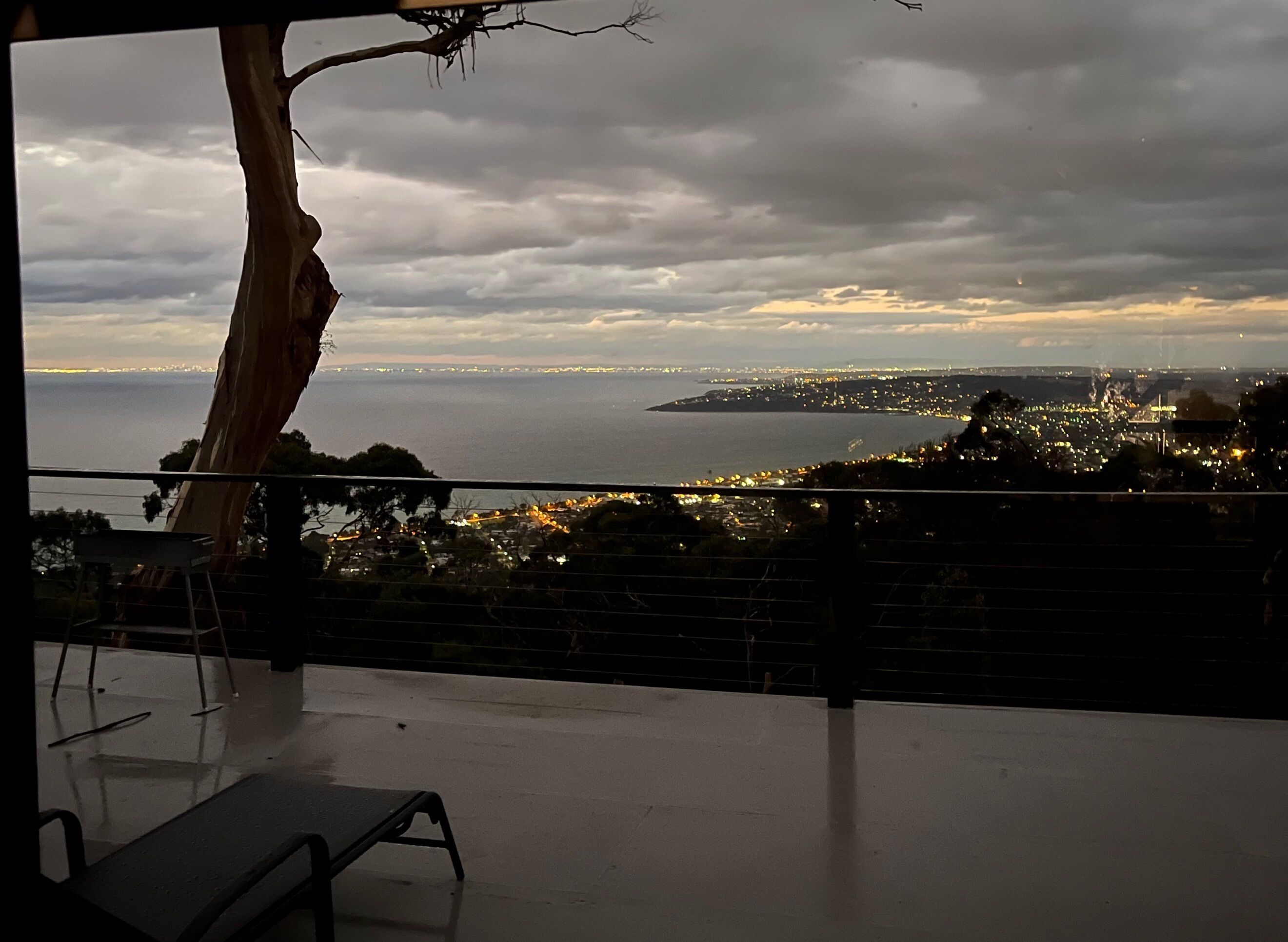 A balcony with a view of a cityscape and the sea.