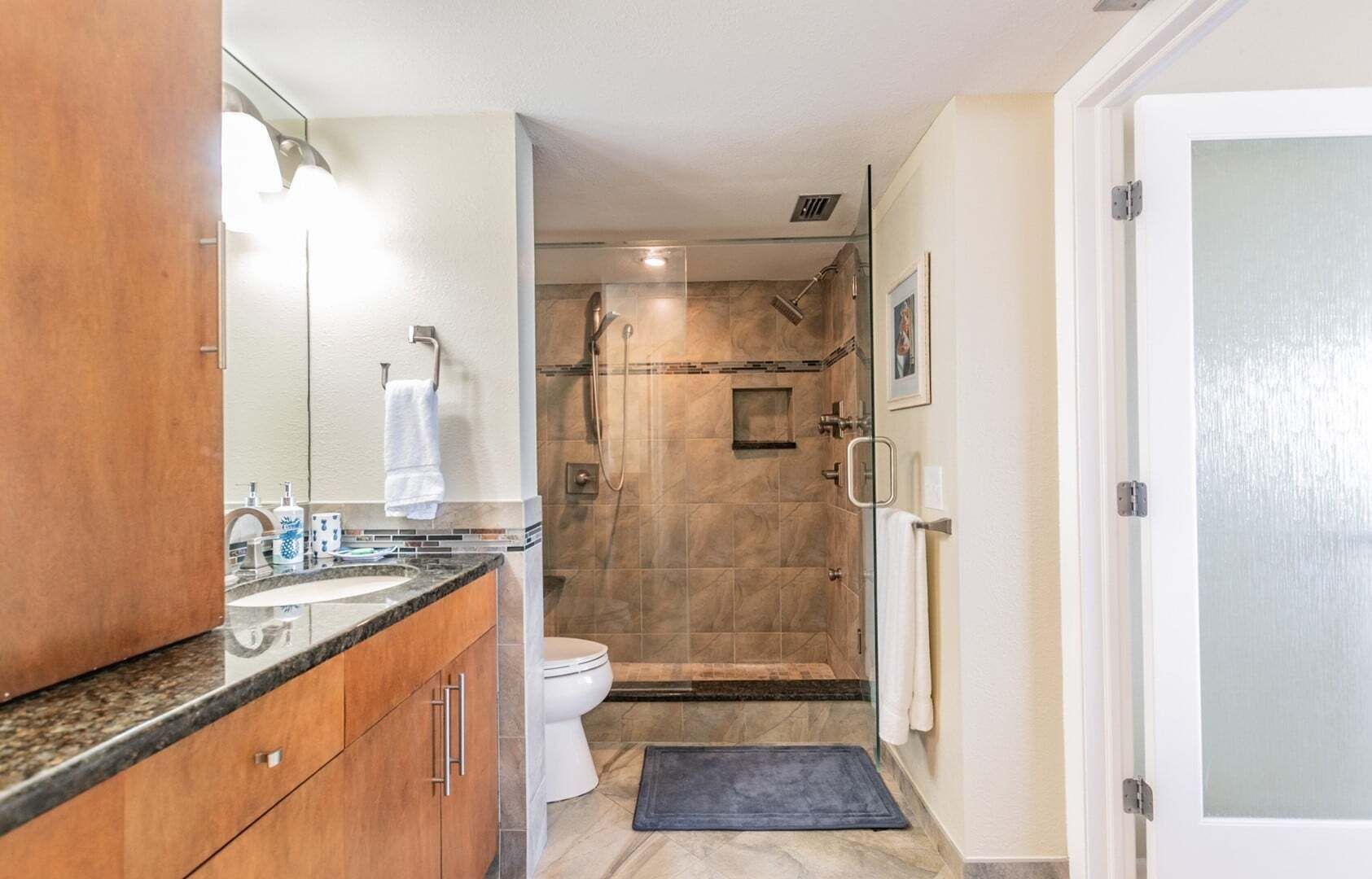 A bathroom with a shower, toilet, and sink.