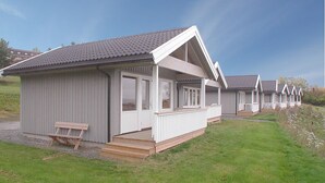 A row of single-story mobile homes with a porch and a picnic table. - Hedmarktoppen (Hamar)
