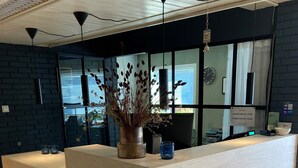 A reception desk with a vase of dried flowers, a clock, and a sign indicating room rates. - Hedmarktoppen (Hamar)