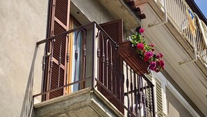 A building with a balcony, a window with shutters, and a flower basket. - An exclusive terraced house in a very central position, 600 meters from the sea. (San Benedetto del Tronto)