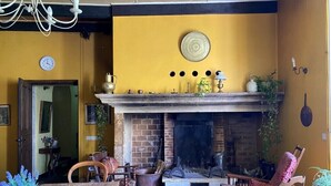 A cozy room with a fireplace, wooden furniture, and a yellow wall. - CAHORS - Family Manor (Douelle)