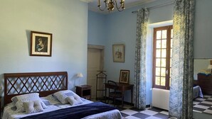A bedroom with a checkered floor, a bed with a wooden headboard, a chandelier, and a window with curtains. - CAHORS - Family Manor (Douelle)