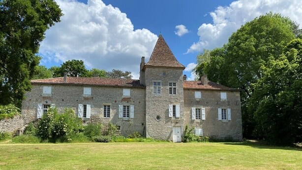 A stone building with a central tower, multiple windows, and a grassy lawn. - CAHORS - Family Manor (Douelle)