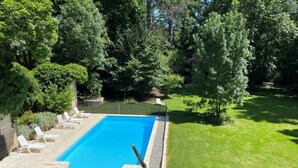 A rectangular swimming pool with a clear blue water surface, surrounded by a concrete deck and a metal fence. - CAHORS - Family Manor (Douelle)