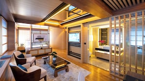 A modern living room with a fireplace, comfortable seating, and a view through a wooden screen. - Hanami Design Hotel (Belgrade)