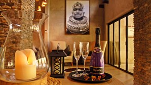 A table with a bottle of PONGRACZ Noble Nectar, two wine glasses, a candle, and a decorative lantern. - Dream of Africa Bush Lodge (Nkomazi)