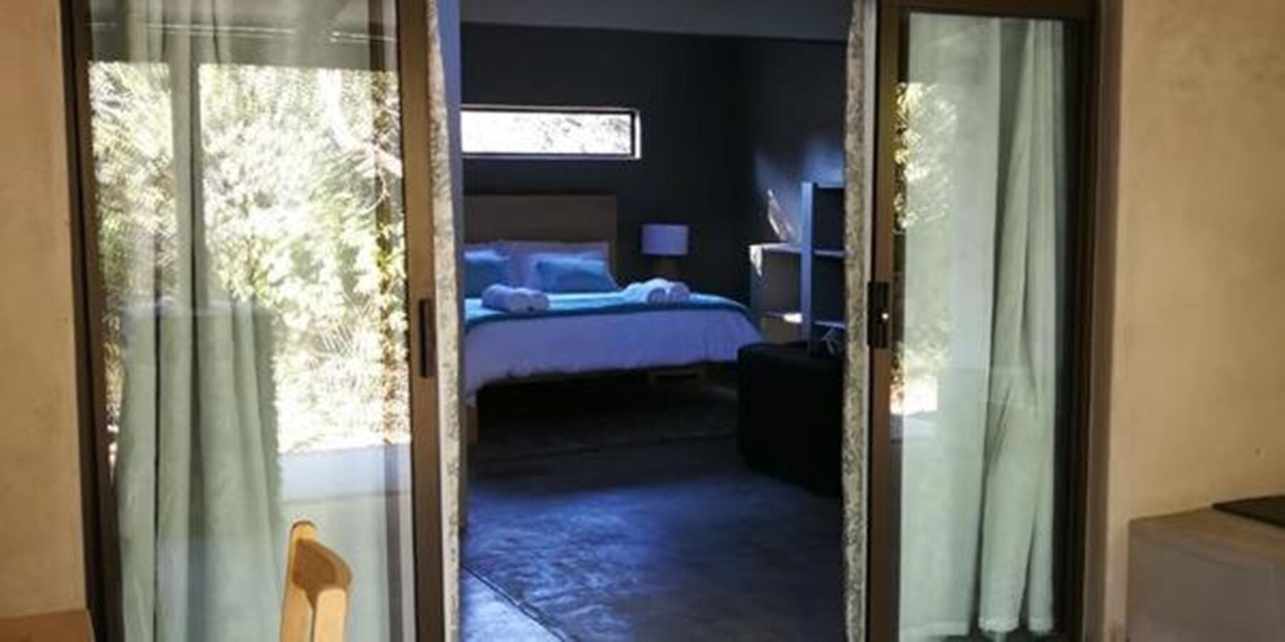 A hotel room with a bed, a desk, and a chair.