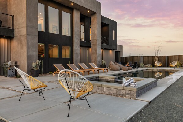 A modern outdoor patio with lounge chairs, a pool, and a barbecue grill. - Sundance Cove by Fieldtrip - Modernist Masterpiece Next to National Park Camp Entrance (Twentynine Palms)