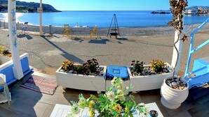 A covered outdoor seating area with a view of the beach and sea. - Beach Shack Studio s&l (Rhodes)