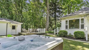 Ein Garten mit Whirlpool, Liegestühlen und einem Haus.