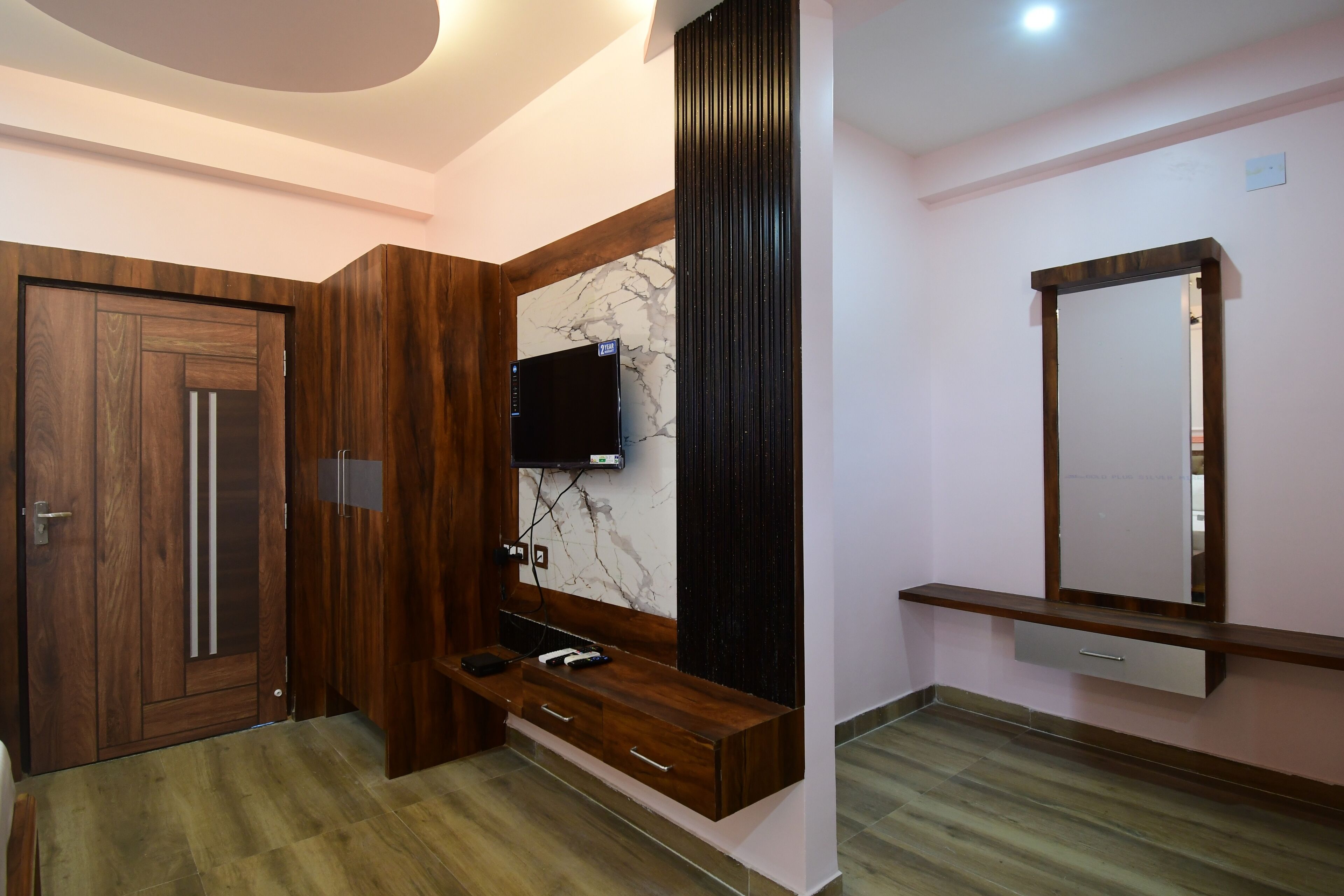 A modern bathroom with a wooden vanity, a marble backsplash, and a wall-mounted mirror.