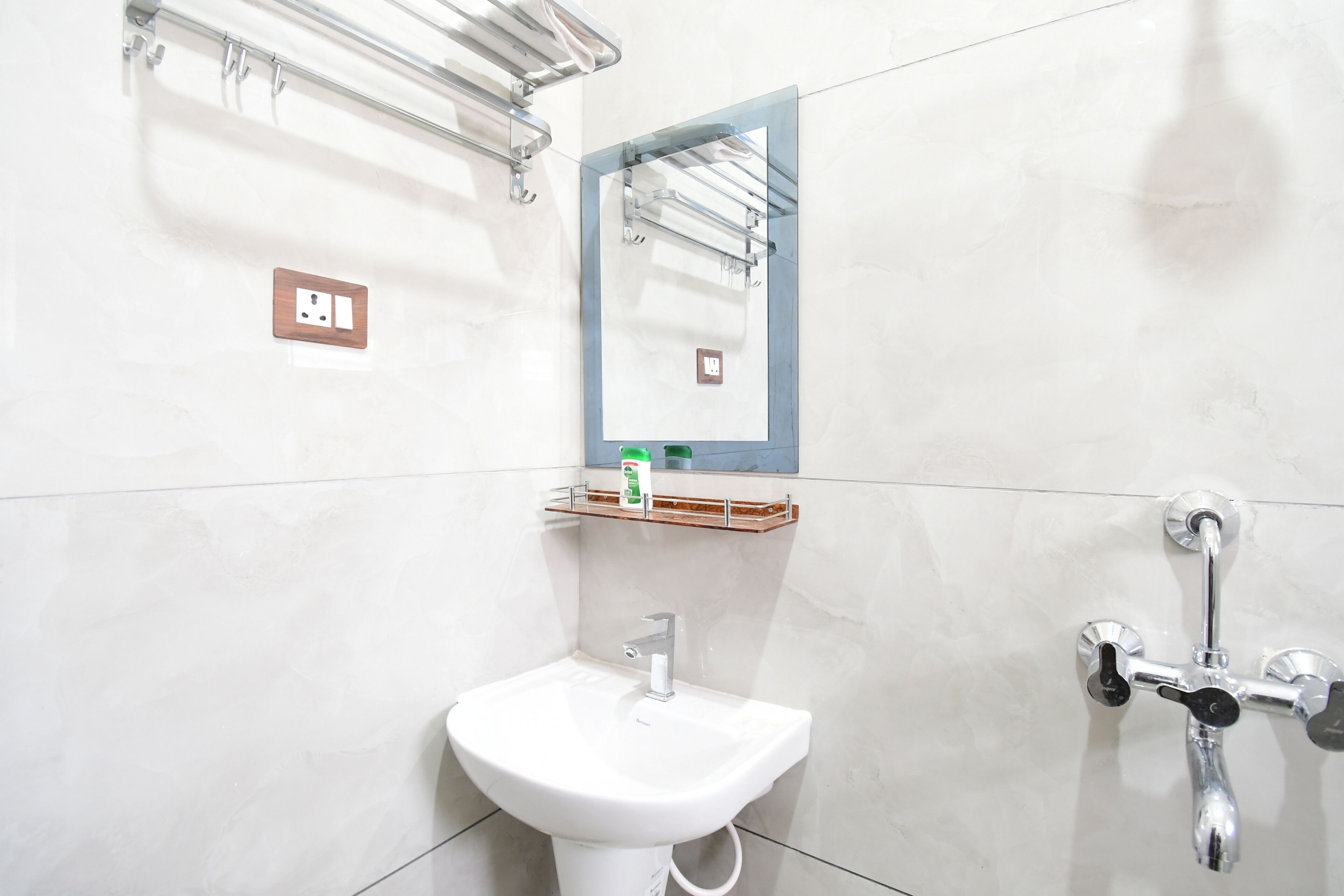 A bathroom with a white sink, a mirror, and a shower.