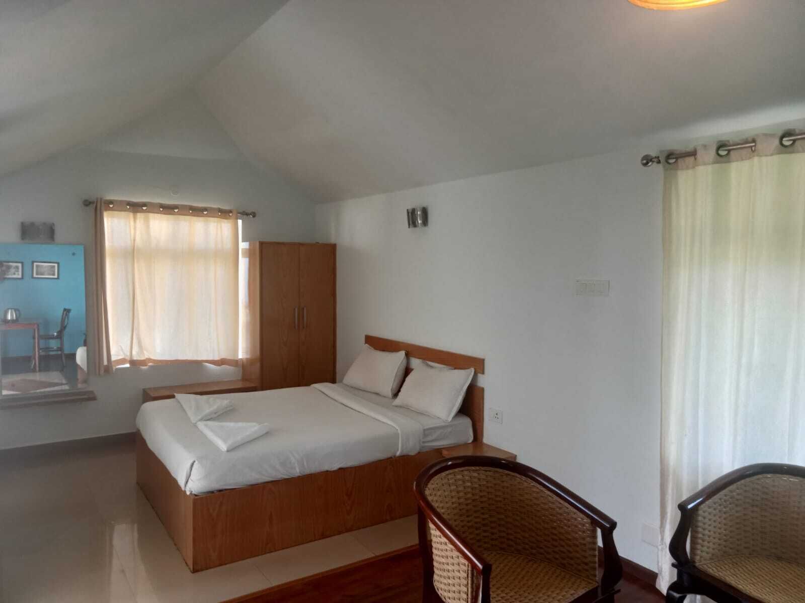 Un dormitorio con cama, armario de madera y una silla.