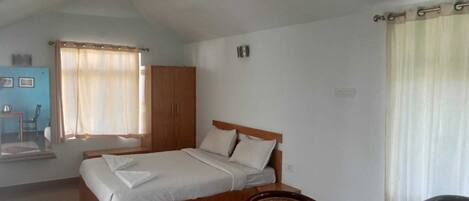 Un dormitorio con cama, armario de madera y una silla.