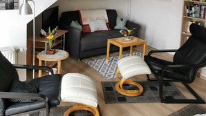 A modern living room with a sofa, two armchairs, a coffee table, and a bookshelf. - Künstlerkolonie Ahrenshoop (Ostseebad Ahrenshoop)