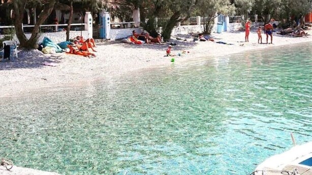 A beach with clear water, trees, and a few people. - Nikis seaside house  (KALYMNOS)