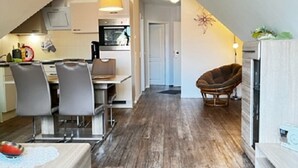 Eine moderne Küche mit Essbereich, Holzboden und einer gemütlichen Sitzecke.
