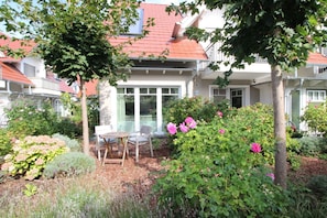 A residential property with a garden, outdoor seating, and a red-tiled roof. - Zentrale Ruhige Lage (Ostseebad Wustrow)