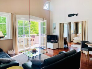 Relax in a spacious living area with a sofa, dining table, and TV, offering a comfortable space for relaxation and entertainment.
