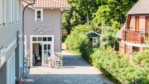 Ein Gebäude namens 'Rose' mit rotem Ziegeldach, einer Ziegel-Fassade und einem Kopfsteinpflasterweg, der zum Eingang führt.