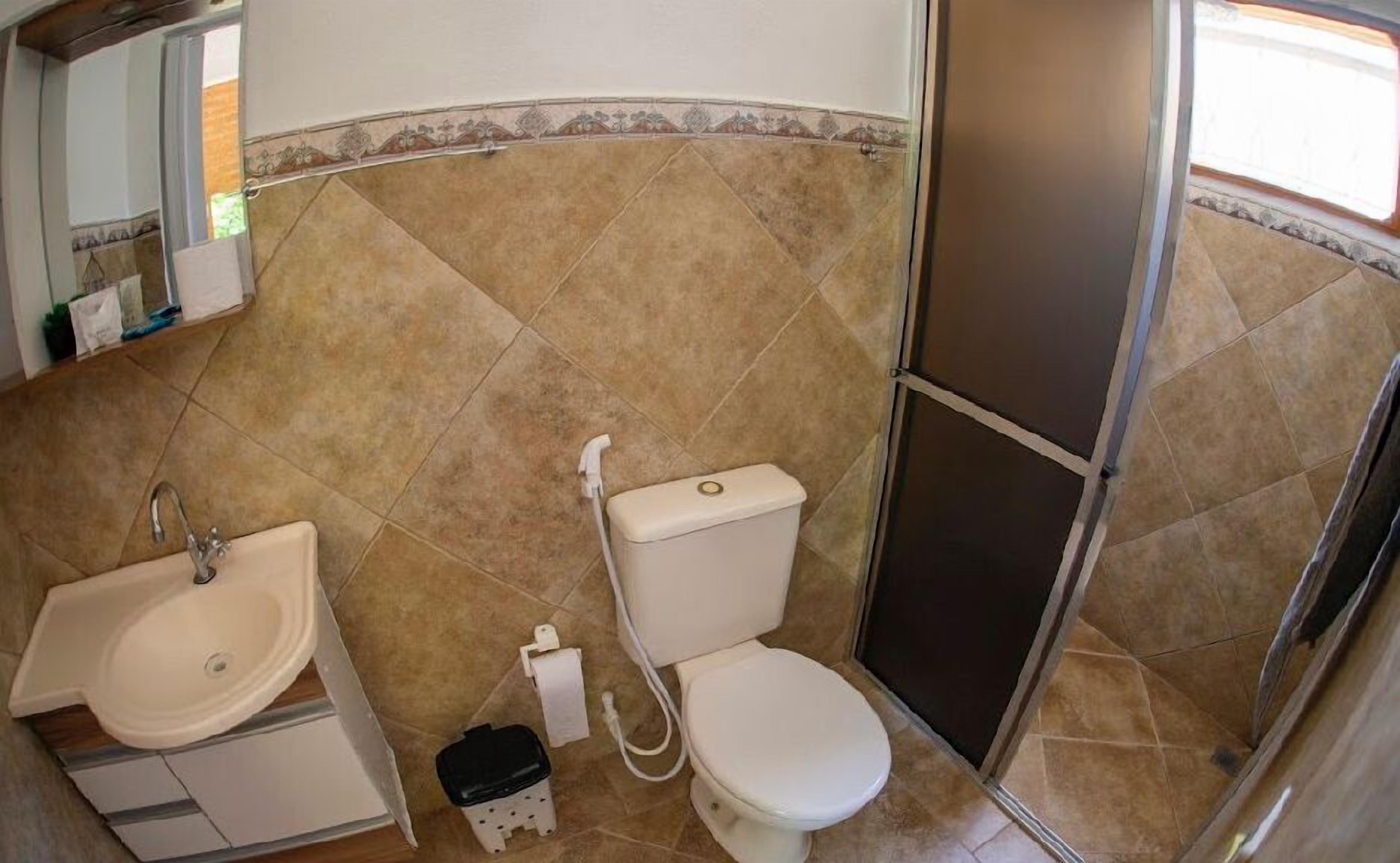 A bathroom with a sink, toilet, and shower.