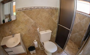 A bathroom with a sink, toilet, and shower. - Chalés Sapucaí (São Bento do Sapucaí)