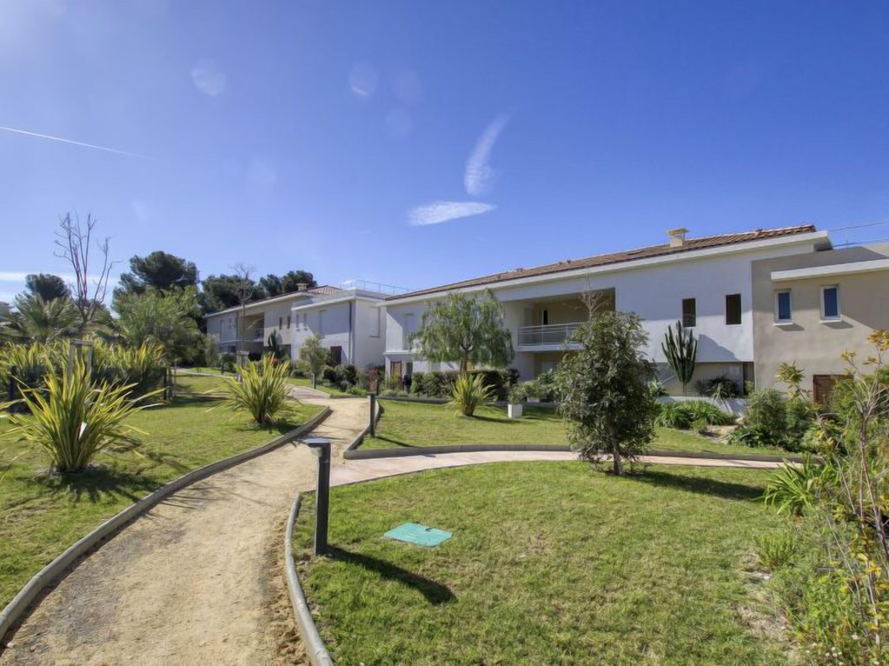 A modern two-story residential building with a flat roof and a balcony on the second floor.