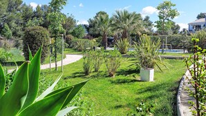 A garden with a pathway, various plants, and a pool. - Les Terrasses d'Azur by Interhome (Sanary sur Mer)