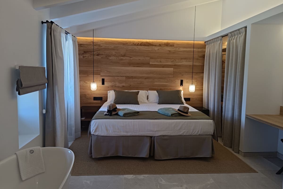 Una habitación de hotel moderna con una cama grande, un escritorio integrado y un baño separado.