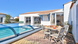 Propiedad residencial con piscina, zona de estar al aire libre y patio.