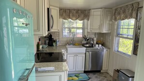 A kitchen with white cabinets, a stainless steel dishwasher, and a teal refrigerator. - Amazing lake house with everything you need!  (Ashford)