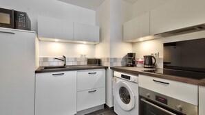 A compact kitchen with a washing machine, a microwave, and a coffee maker. - Ecapade for 4 in Pléneuf-Val-André (Pléneuf-Val-André)