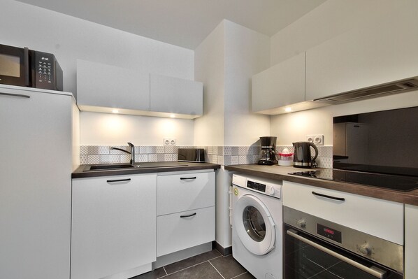 A compact kitchen with a washing machine, a microwave, and a coffee maker. - Ecapade for 4 in Pléneuf-Val-André (Pléneuf-Val-André)