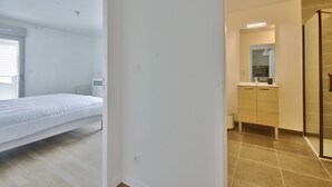 A bedroom with a bed, a small bedside table, and a window. - Ecapade for 4 in Pléneuf-Val-André (Pléneuf-Val-André)