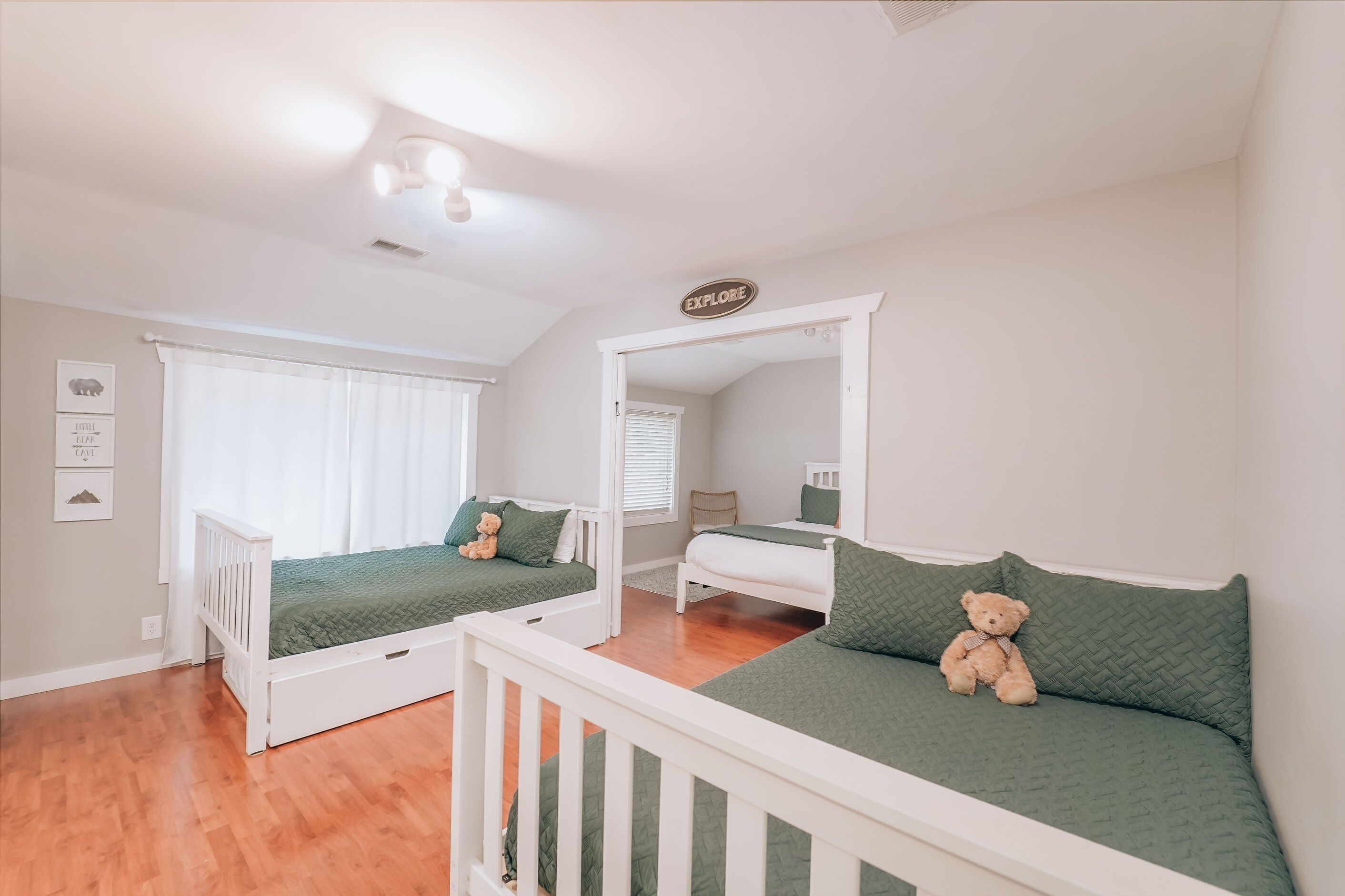 A bedroom with two beds, a white ceiling, and a sign that says "EXPLORE".