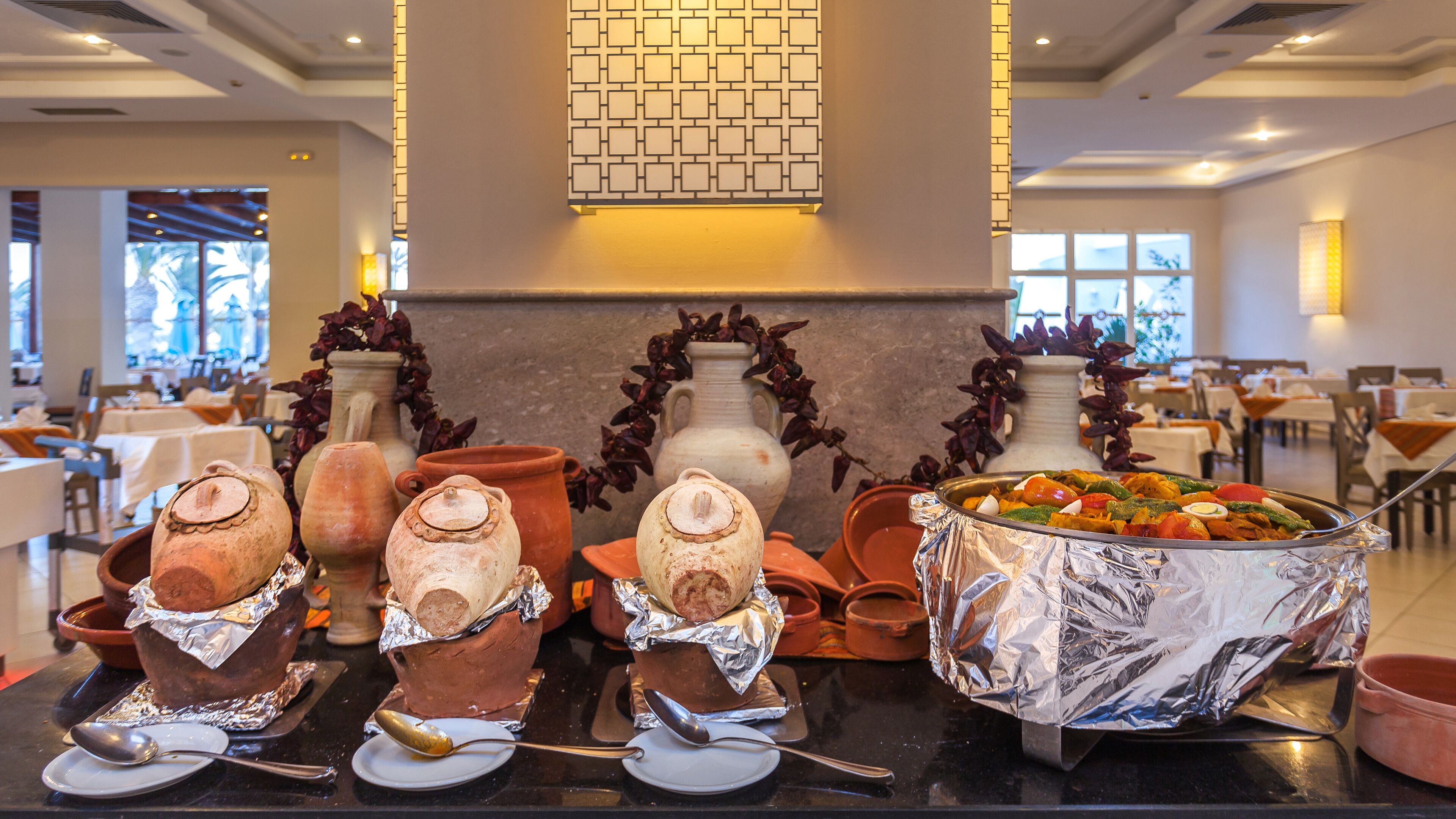 A buffet setup with various dishes and pottery.
