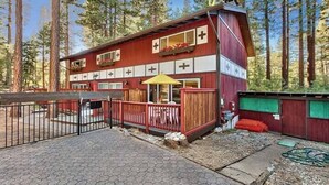 Un bâtiment rouge et blanc doté d’un patio couvert et d’une zone délimitée par une clôture.