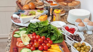 A breakfast buffet with various food items and utensils. - Villa Venusta (Hermanus)