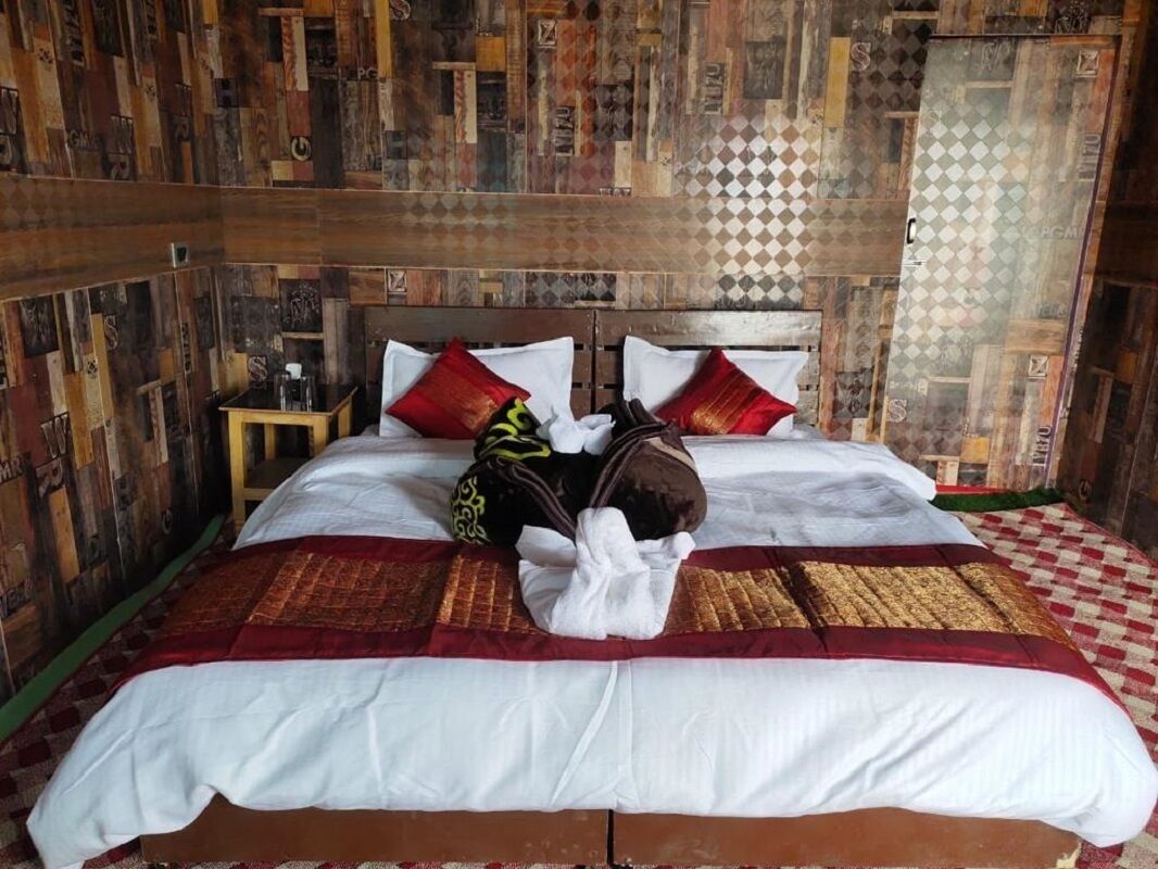 A bed with a checkered bedspread, two pillows, and a blanket.
