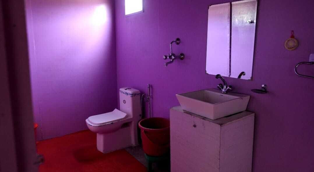 Une salle de bain avec des toilettes, un lavabo et un miroir.